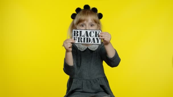 Child girl showing Black Friday inscription, smiling, looking satisfied with low prices, discounts — Stock Video