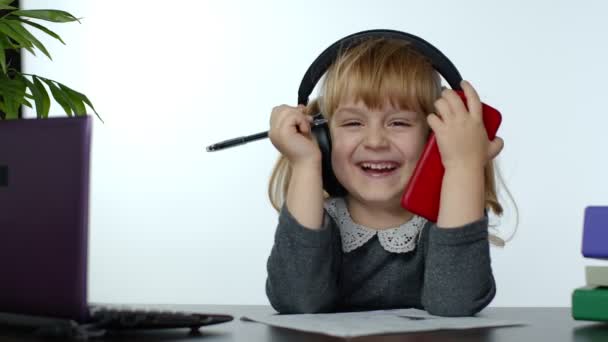 Barnflicka skrattar och ler. Lärande i hemmet och användning av digital smartphone — Stockvideo