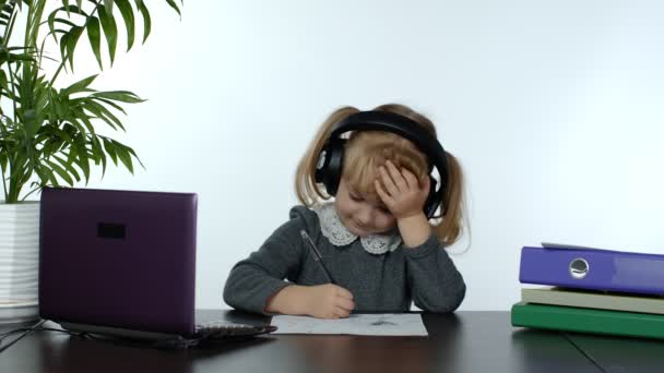 학교다니기 전 여자 아이가 인터넷으로 집에서 배우는 거리. 디지탈 랩탑 컴퓨터를 사용하여 공부하는 아이 — 비디오