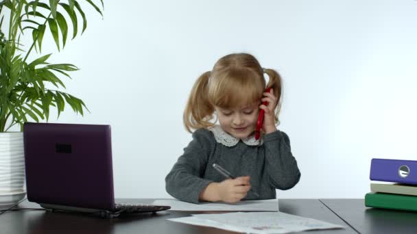 Zabawne małe dziecko dziewczyna szef kierownik emocjonalnie rozmawia przez telefon komórkowy, siedzi przy stole komputerowym — Wideo stockowe