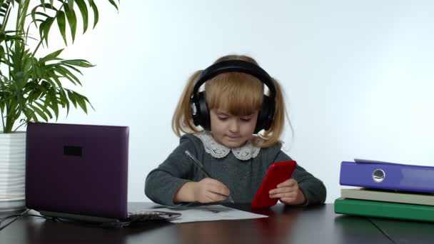 Teenager-Schulmädchen mit drahtlosen Kopfhörern rufen Lehrer auf dem Handy. Fernstudium — Stockvideo