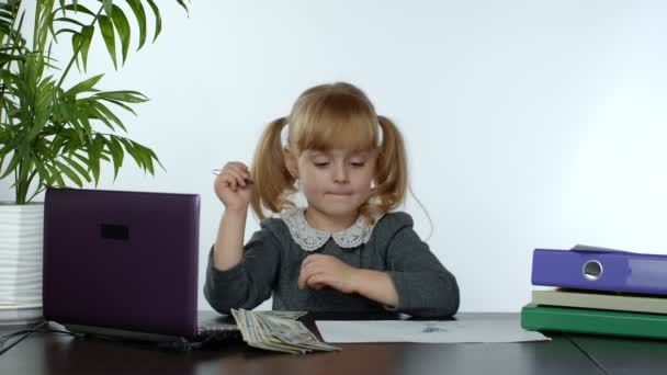 Дівчинка-голова рахує доларові готівкові рахунки. Дитяча бізнес-леді дитина з грошима сидить в офісі — стокове відео