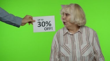 % 30 'a yakın indirim büyükannenin yanında görünüyor. Alışveriş torbalarıyla kutlama yapan kadın.