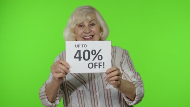 Senior grootmoeder tonen tot 40 procent Off inscriptie teken, verheugen kortingen, lage prijzen — Stockvideo