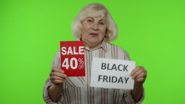 Senior grootmoeder tonen Black Friday, 40 Procent Off korting reclame banners. Chromatoetsen — Stockvideo