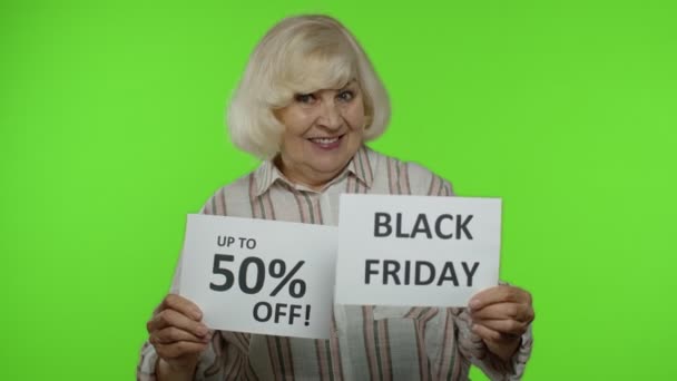 Großmutter zeigt Black Friday und bis zu 50 Prozent Rabatt auf Rabattwerbung — Stockvideo