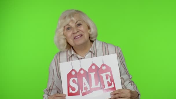 Grandes descuentos de compras para abuelos mayores. anciana abuela mujer mostrando venta palabra banner — Vídeo de stock