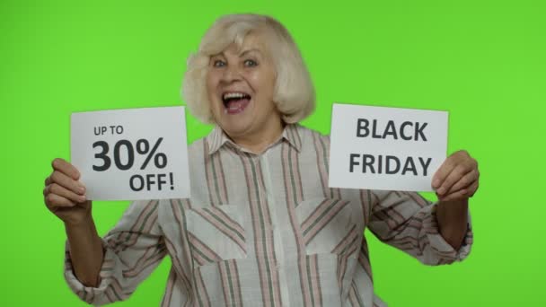 Abuela mayor mostrando Viernes Negro, 30 por ciento de descuento en banners de publicidad de descuento. Clave de croma — Vídeos de Stock