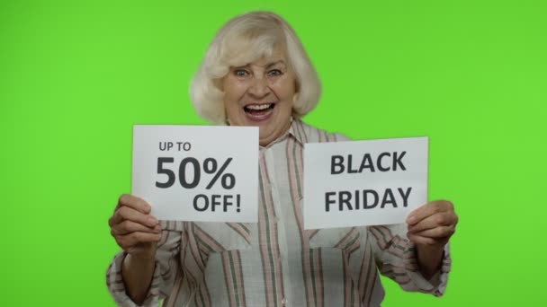 Grandmother showing Black Friday and Up To 50 Percent Off shopping price discount advertisement — Stock Video