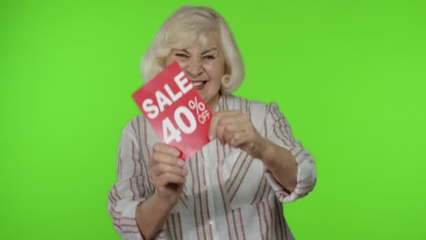 Senior γιαγιά δείχνει Πώληση 40 τοις εκατό off banner διαφήμιση. Online αγορές. Μαύρη Παρασκευή — Αρχείο Βίντεο