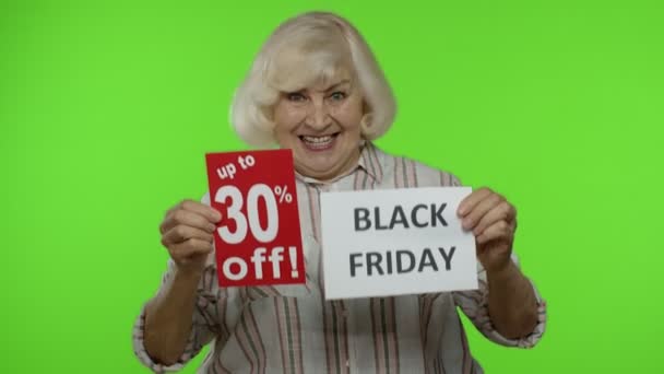 Starší babička ukazuje Černý pátek, 30% sleva reklamní bannery. Klíč Chroma — Stock video