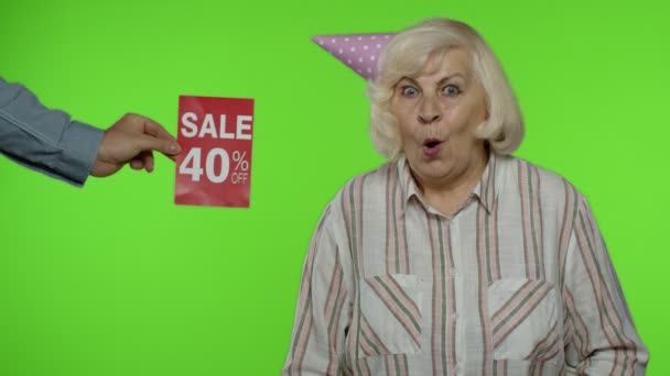 Anuncio Venta 40 por ciento de descuento aparece junto a la abuela. Mujer celebrando con bolsas de compras — Vídeos de Stock