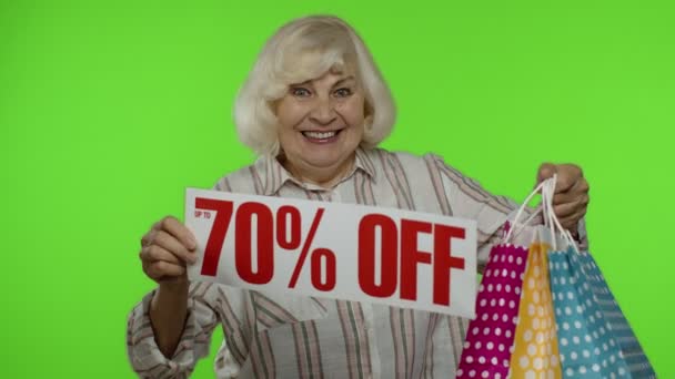 Nonna con le borse della spesa che mostrano fino al 70 per cento di sconto banner. Shopping online a prezzi bassi — Video Stock