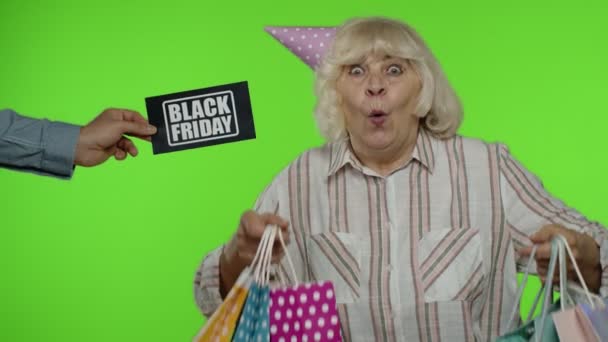 Publicidade inscrição Black Friday aparece ao lado da avó alegre com sacos de compras — Vídeo de Stock