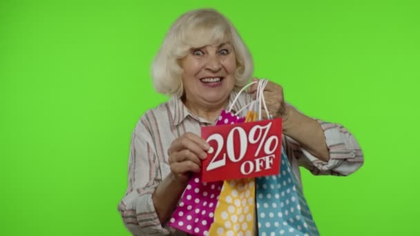 Mormor visar 20% rabatt på skyltar och kassar. Shopping på Black Friday — Stockvideo