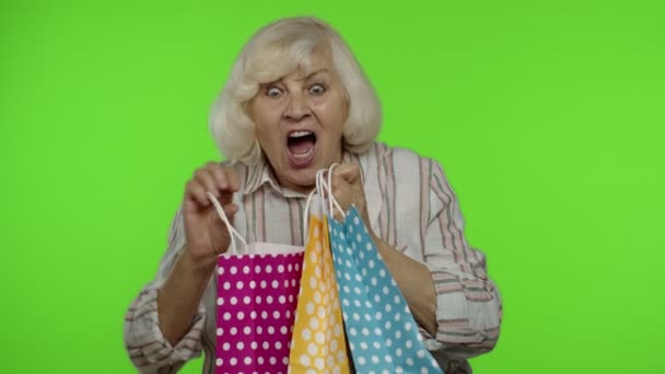 Senior grootmoeder tonen Black Friday inscriptie uit boodschappentas, glimlachen, verheugen kortingen — Stockvideo