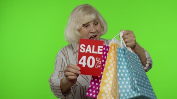 쇼핑 가방을 든 쾌활 한 할머니가 현수막 문자 광고의 40 퍼센트를 내는 모습 — 비디오