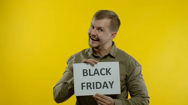 Joyful man showing Black Friday inscription note, smiling looking satisfied with low prices — Stock Photo, Image