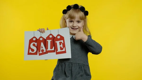 Tolle Rabatte für Vorschulkinder. Ein Mädchen mit einem Banner mit der Aufschrift "Verkauf". Schwarzer Freitag — Stockfoto