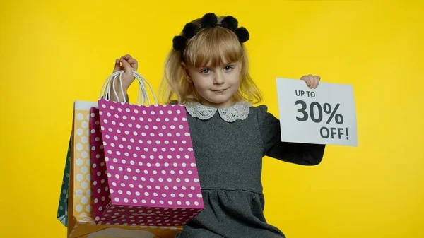 小女孩展示高达30%的非注册标志和购物袋。小学生笑了 — 图库照片