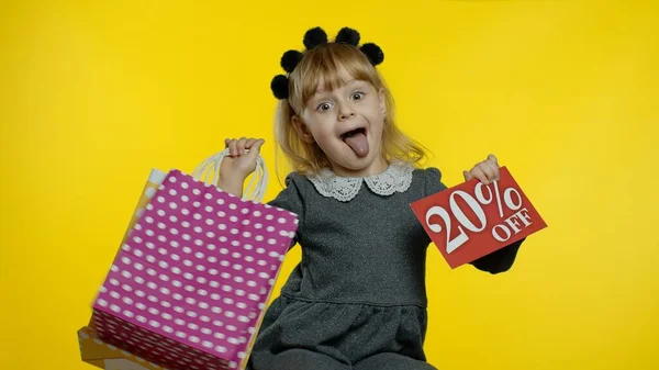Ein schülerblondes Mädchen mit Einkaufstüten, auf denen 20 Prozent der Werbebanner zu sehen sind. Ferienverkauf — Stockfoto