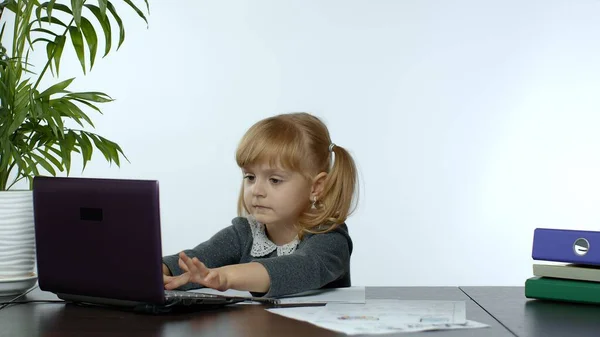 Онлайн-обучение, дистанционное обучение, урок на дому. Девочка делает школьную программу онлайн на компьютере — стоковое фото