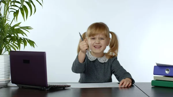 Онлайн-обучение, дистанционное обучение, урок на дому. Девочка делает школьную программу онлайн на компьютере — стоковое фото
