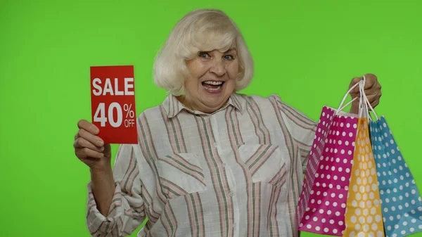 Весела бабуся з сумками з рекламним повідомленням на 40 відсотків — стокове фото