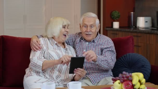 Vieux vieux couple grands-parents parlant et utilisant ordinateur tablette numérique à la maison. Achats en ligne — Video