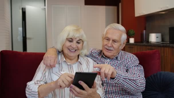 Anziani nonni coppia di parlare e utilizzando computer tablet digitale a casa. Shopping su Internet — Video Stock