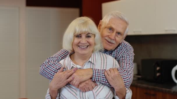 Старшая пара на пенсии бабушки и дедушки муж и жена счастливые лица обнимаются дома, обнимаются, смеются — стоковое видео