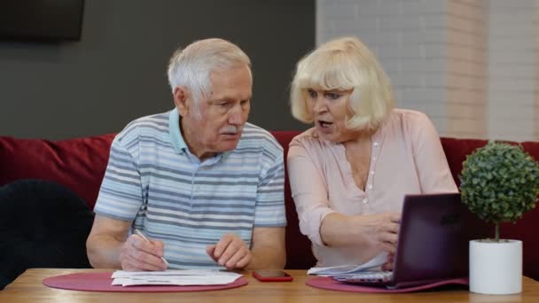 Stres senior pár diskutovat nezaplacené bankovní dluh držení směnky, dělat papírování, plánování rozpočtu — Stock video