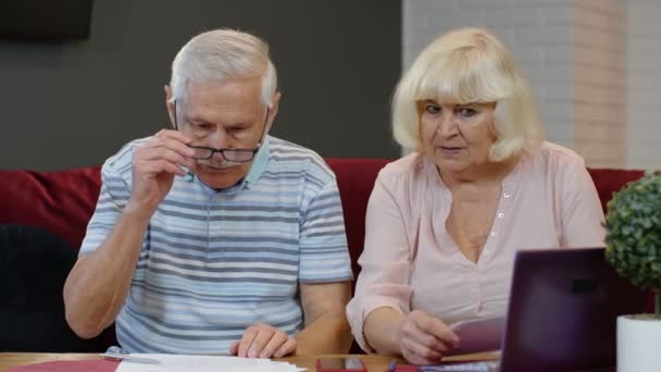 Couple senior vérifiant les papiers, les factures nationales, la planification du budget d'investissement paiement d'assurance prêt — Video