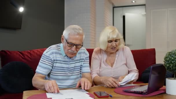 Parejas mayores revisando papeles, facturas domésticas, planificación presupuesto inversión préstamo seguro pago — Vídeo de stock