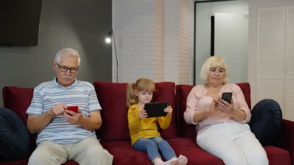 Abuelos de pareja mayor con nieta niña usando tableta digital, teléfono móvil — Vídeos de Stock