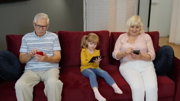 Abuelos de pareja mayor con nietos de niña usando tableta digital, teléfono móvil — Vídeos de Stock