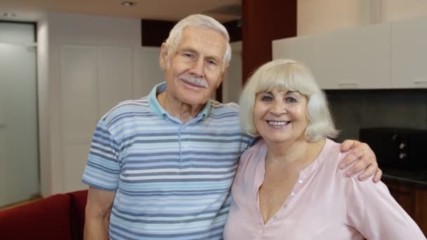 Yaşlı çift emekli oldu, karı koca mutlu yüzler evde kucaklaşıyor, sarılıyor, gülüyor. — Stok video
