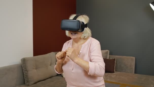 Gelukkig senior vrouw in virtual reality headset bril, proberen om iets aan te raken, kijken naar 3D-video — Stockvideo