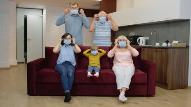 Coronavirus karantän nedstängning koncept. Familjen sätter medicinska skyddsmasker på ansikten hemma — Stockvideo