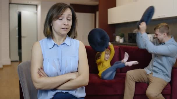 Усталая депрессивная молодая кавказская мать женщина чувствует себя очень раздраженной активным отцом и дочерью ребенка — стоковое видео