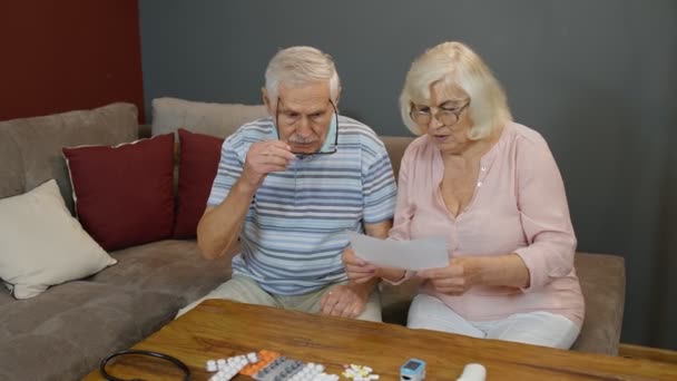 Pasangan senior mencari resep obat, pil, tablet di rumah. Penguncian Coronavirus — Stok Video