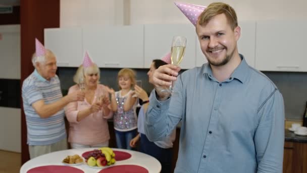 Urodzinowy człowiek trzymający kieliszek szampana patrzący w kamerę. Ojciec świętuje jubileuszowe wakacje — Wideo stockowe