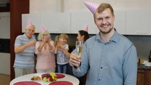 Geburtstagskind hält ein Glas Champagner in die Kamera. Vater feiert Jubiläum — Stockvideo