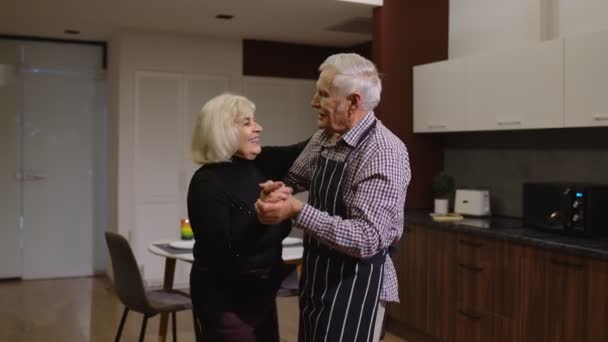 Senior couple in love dancing. Romantic evening supper with wine and candles celebrating anniversary — Stock Video