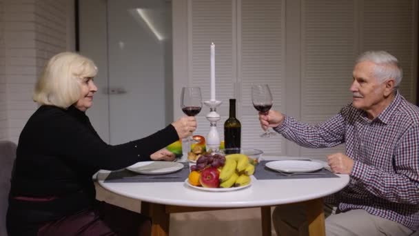 Senior entspannt Paar zu Hause beim Abendessen und Gläser Rotwein trinken in der Küche — Stockvideo