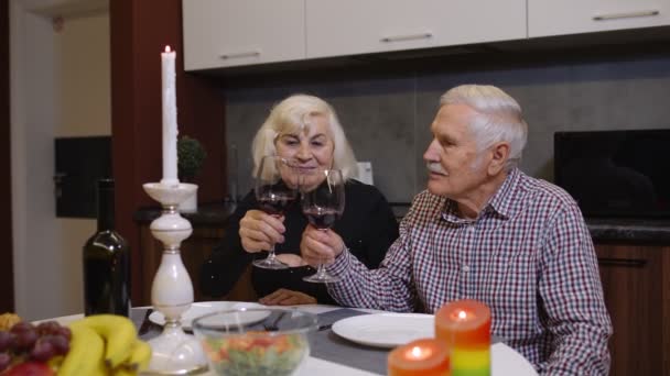 Portret starszej pary pijącej wino w domu podczas romantycznej kolacji w kuchni w domu — Wideo stockowe