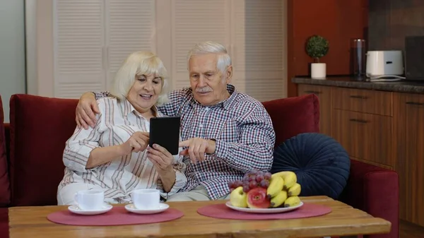 Abuelos mayores pareja hablando y usando tableta digital en casa. Bloqueo del Coronavirus — Foto de Stock