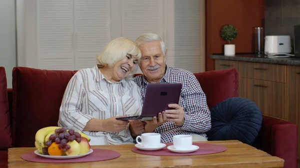 Abuelos mayores pareja hablando y utilizando la computadora portátil digital en casa. Bloqueo del Coronavirus — Foto de Stock