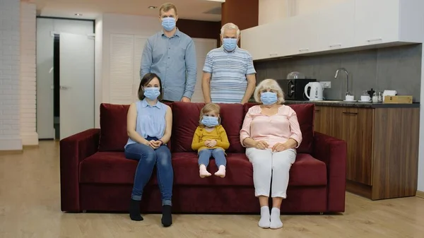 Coronavirus quarantine lockdown concept. Family in medical protective masks on faces at home