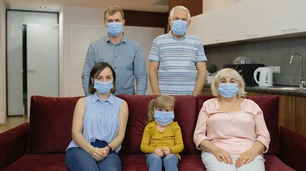 Η ιδέα του αποκλεισμού του ιού της καραντίνας. Οικογένεια με ιατρικές προστατευτικές μάσκες σε πρόσωπα στο σπίτι — Φωτογραφία Αρχείου